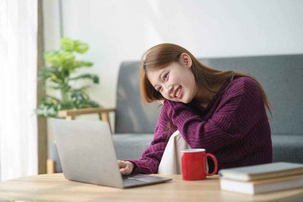 Mulher relaxando em frente ao notbook enquanto assiste videos de ASMR.